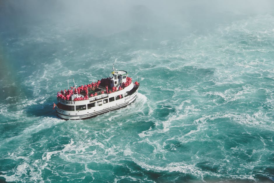 Niagara Falls Small Group Tour w/Helicopter and Maid of the Mist - Aerial view of Maid of the Mist tourist boat amidst turbulent waters at Niagara Falls.