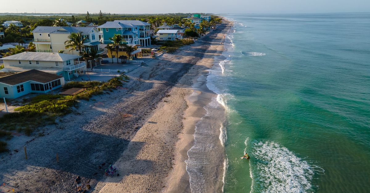 Stunning aerial view of the coastline in Englewood, FL with waves and beachfront houses.