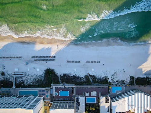 Drone Shot of a Hotel on the Coast and Waves Washing Up the Beach 