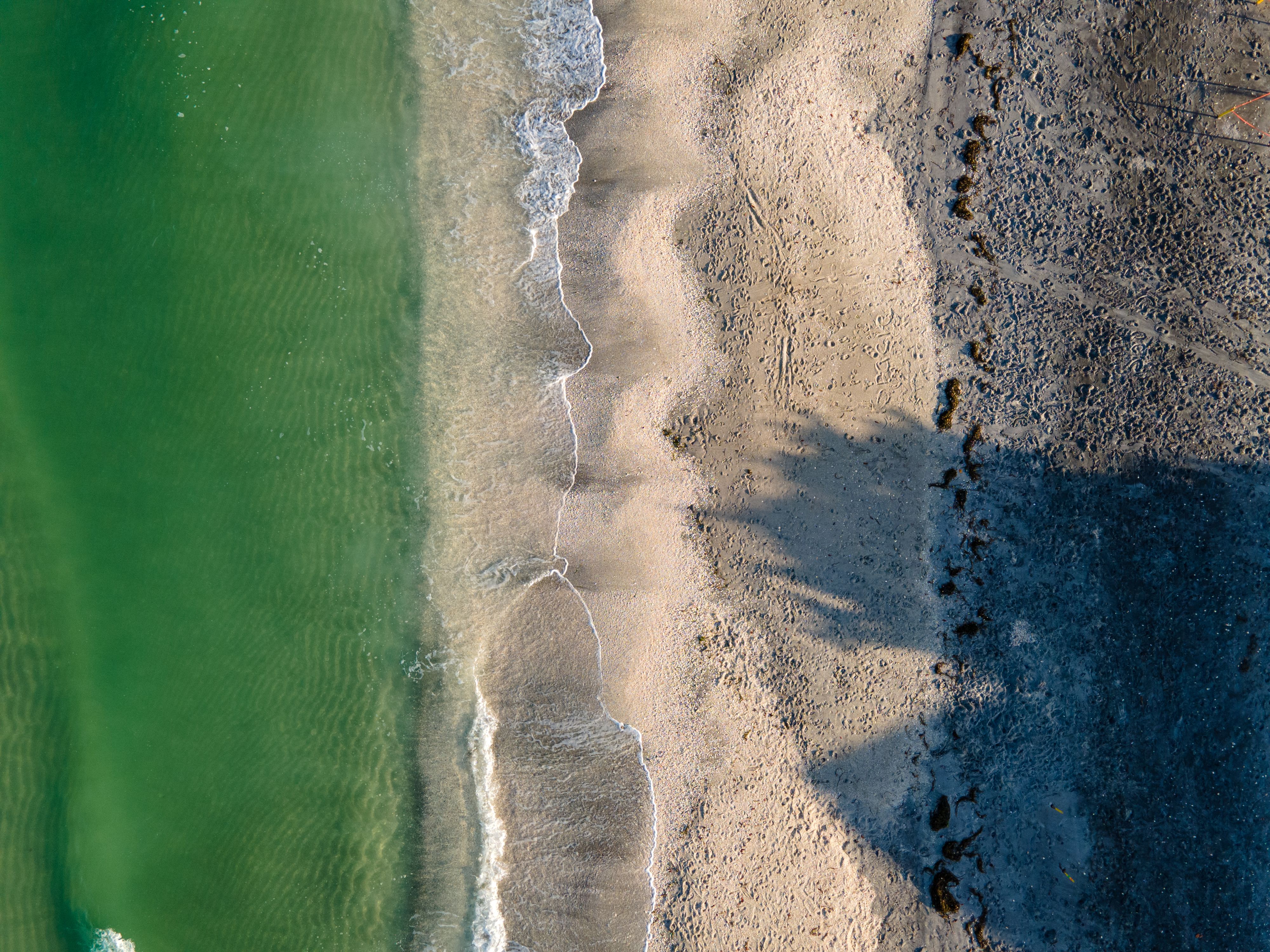 Stunning aerial image of Manasota Key beach showing waves, sand, and shadows.