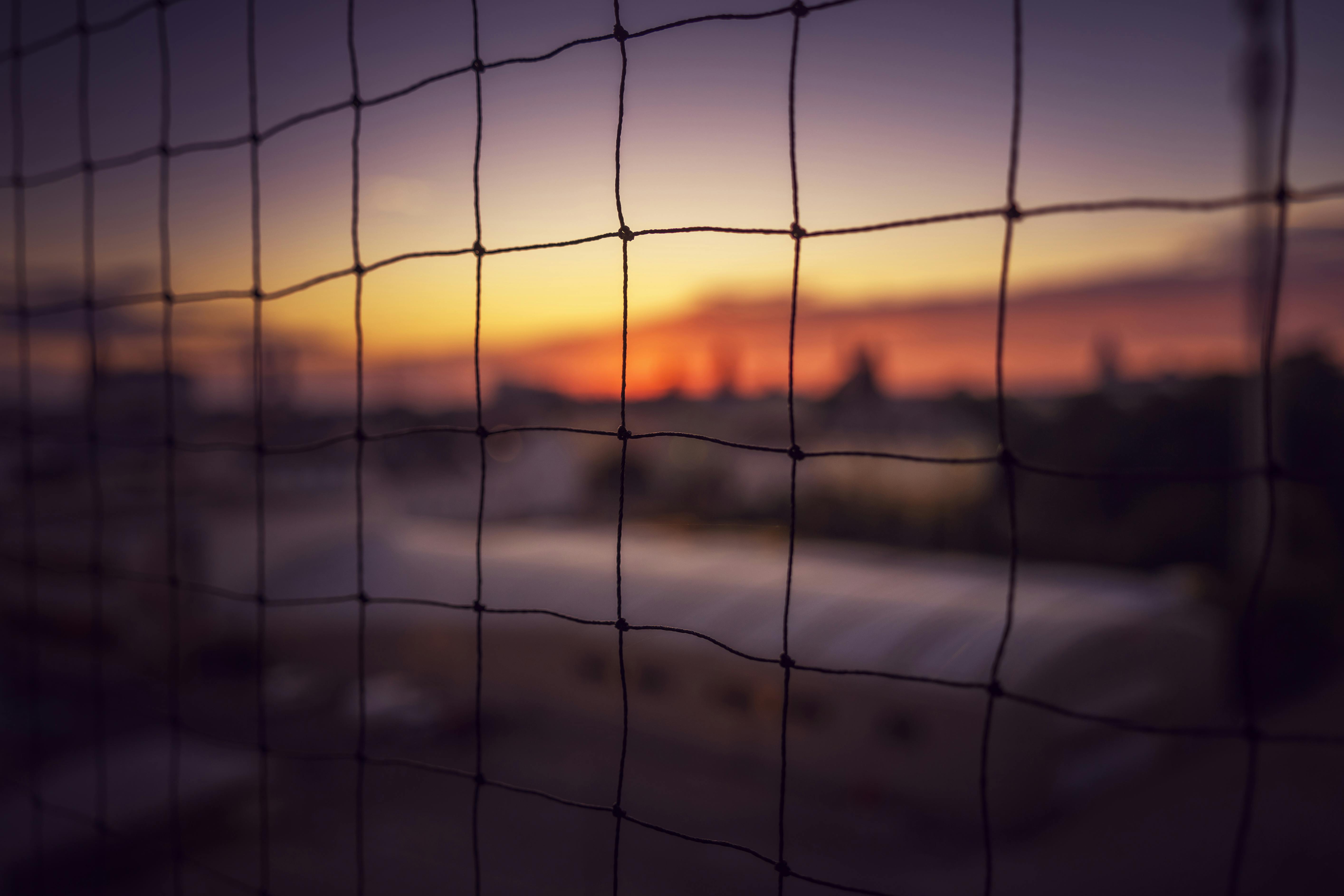 Captivating silhouette view through netting at sunset in Wiener Neustadt, Austria.