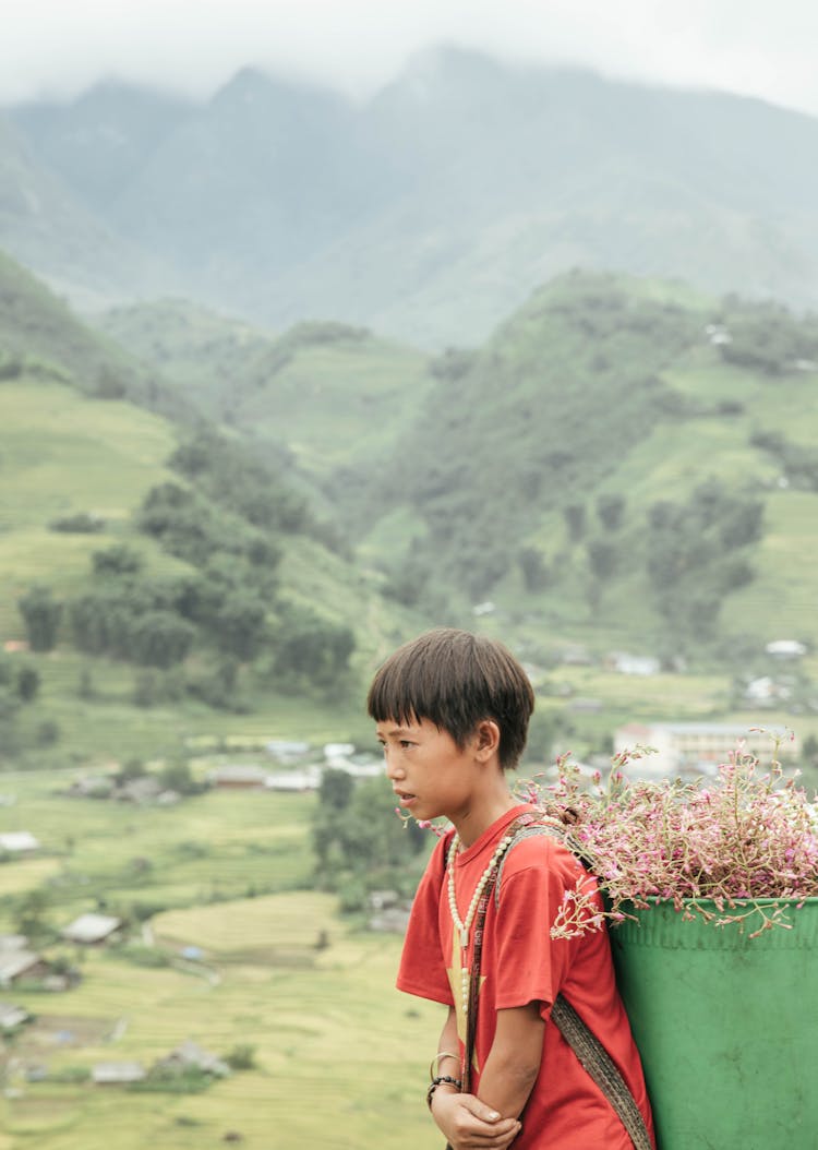 Boy Carrying Flowers In Basket On His Back