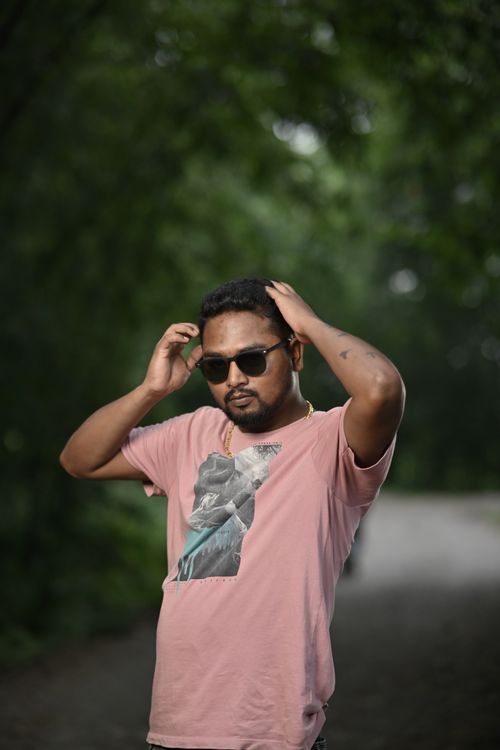 Free Portrait of a stylish man in sunglasses outdoors wearing a pink T-shirt with short hair. Stock Photo