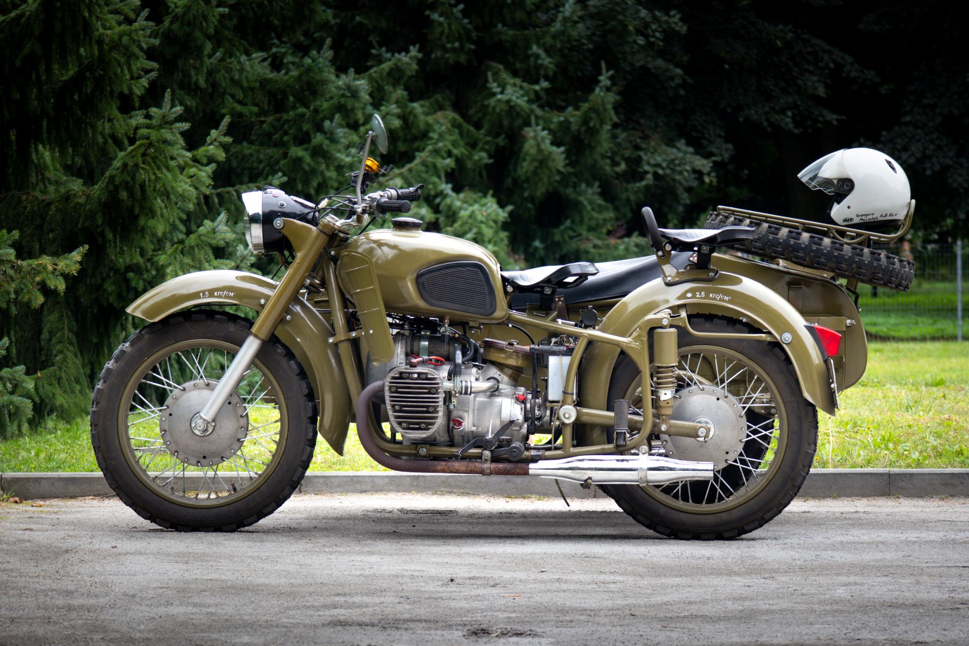 A vintage Ural motorcycle with a helmet parked outdoors in Bierutow, Poland.