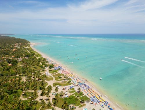 Vista da praia de águas turquesa com várias barracas