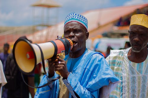 Men in Traditional Clothing Standing with Megaphone