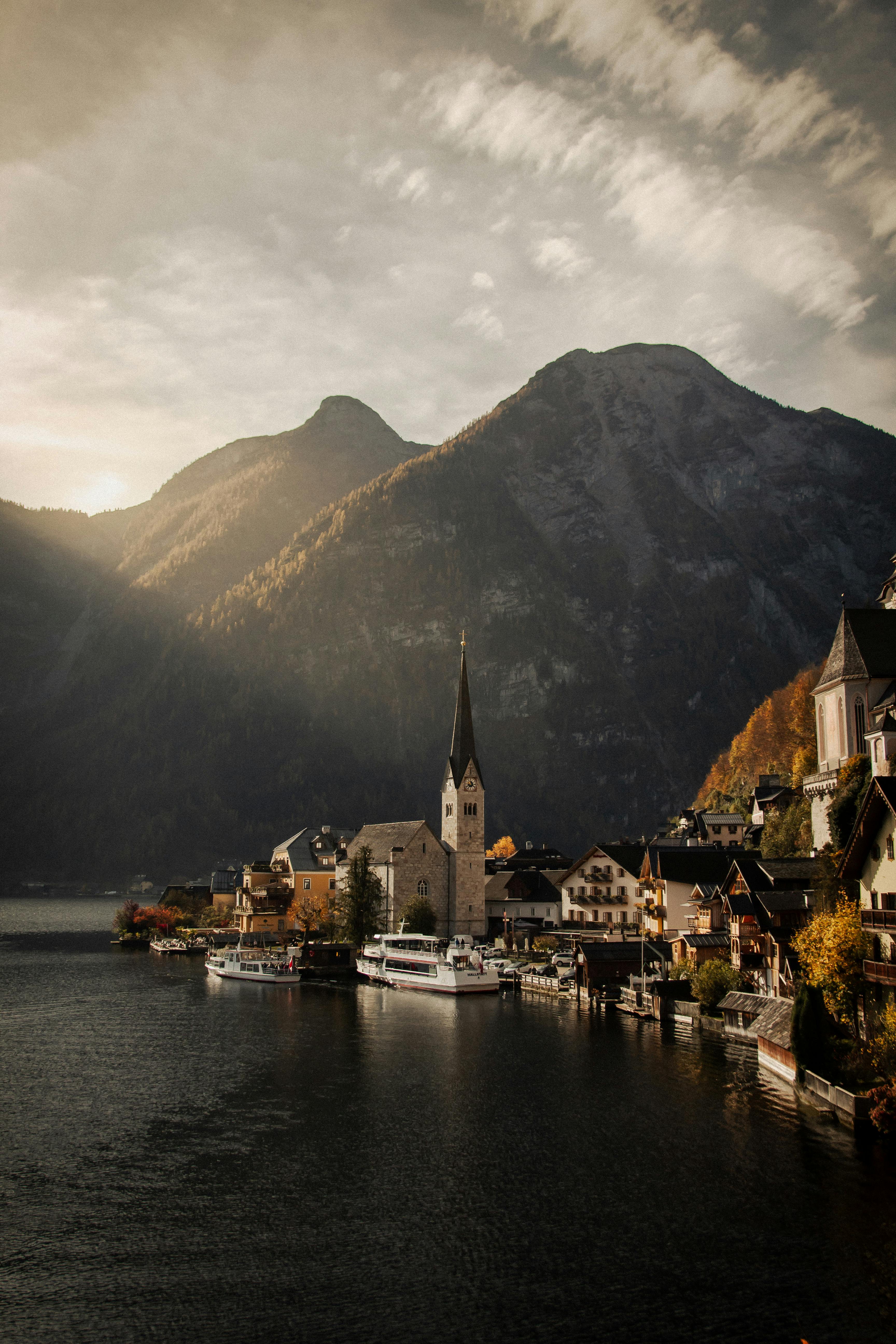 Charming Lake Hallstatt and village nestled in picturesque Alpine setting during sunrise.
