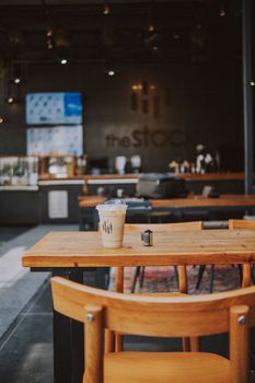 Inviting café interior with iced coffee and camera film on a wooden table.
