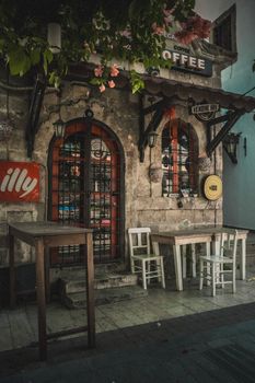 Rustic café with vintage charm, showing tables, chairs, and ornate doors, perfect sunlight for an afternoon coffee.