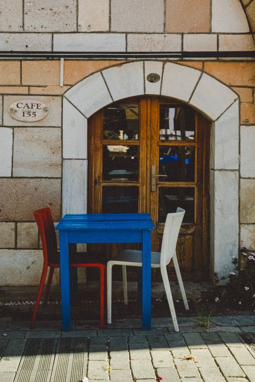 A cafe doorway with chairs on the pavement — photo by Aysegul Aytoren on Pexels