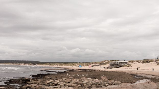 Explore the serene landscape of Lomma Beach with dunes and cloudy skies in Skåne County, Sweden.