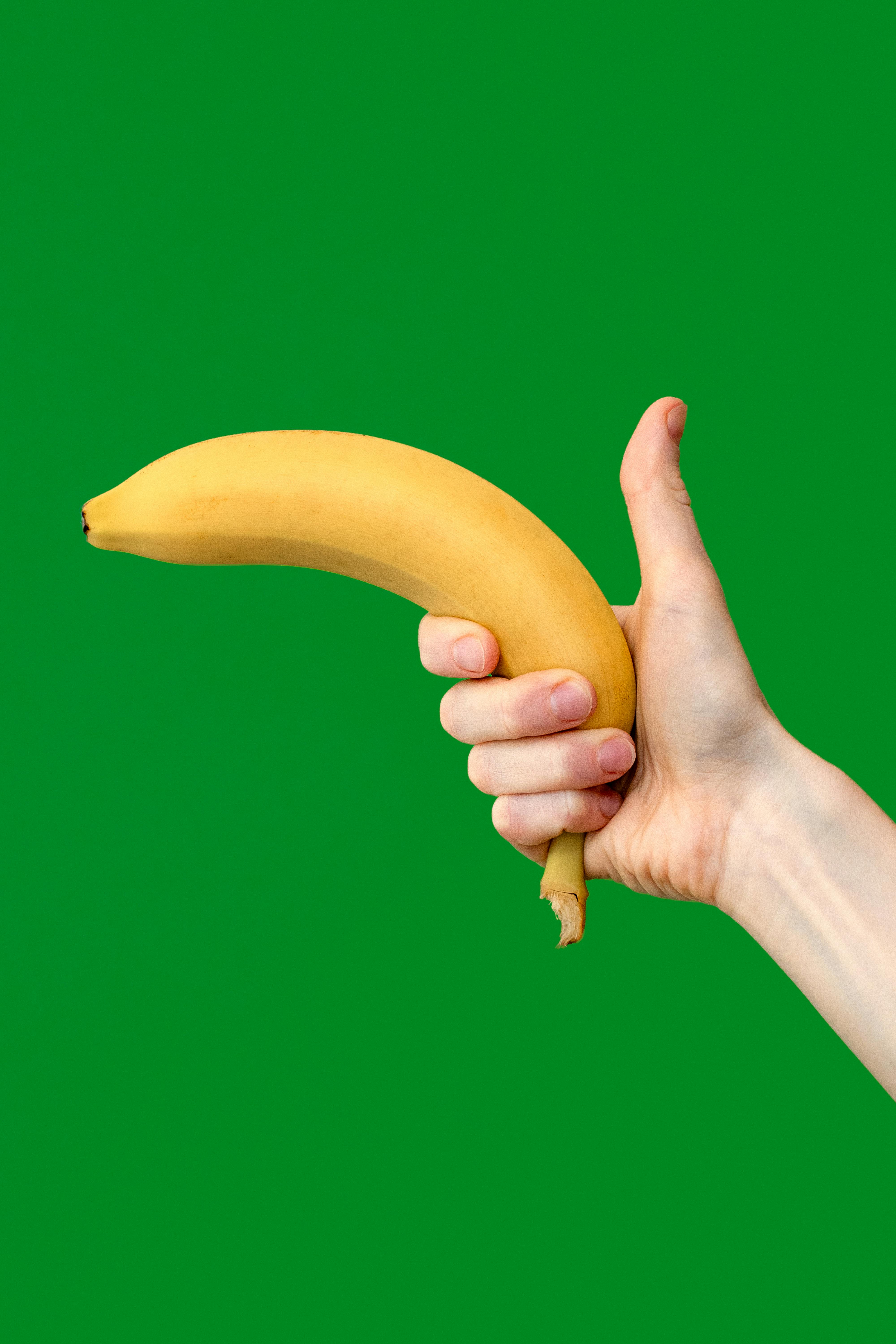 person holding a banana with a thumb up