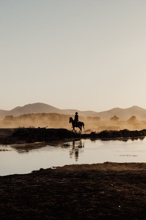Man Horseback Riding by River