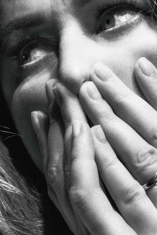 Free Close-up black and white portrait of a surprised woman covering her mouth with hands, expressing emotion. Stock Photo