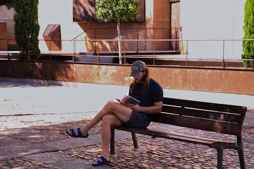 Woman Reading Book on a Bench 