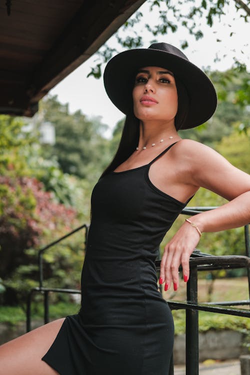 Woman in Mini Black Bodycone Dress and Black Fedora Hat