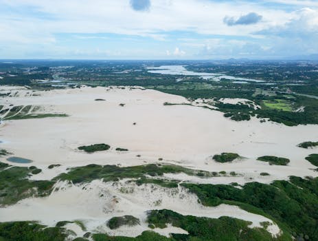 Stunning aerial view of sand dunes surrounded by lush greenery near Fortaleza, Brazil.