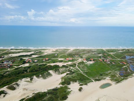 Discover the breathtaking aerial view of Fortaleza's coastline, featuring sandy dunes and lush greenery.