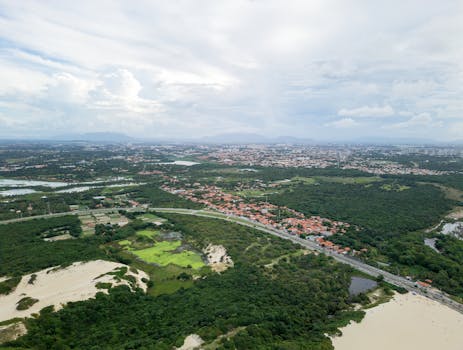 Discover the lush green landscapes surrounding Fortaleza, captured from above, showcasing urban and natural beauty.