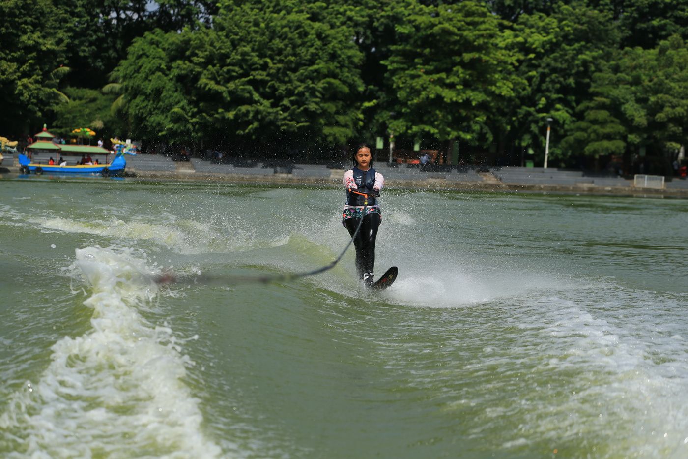 Woman water skiing while wearing suitable water-sports equipment
