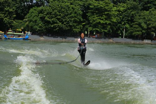 Free A woman enjoys an exciting water skiing adventure in a lush, green outdoor setting. Stock Photo