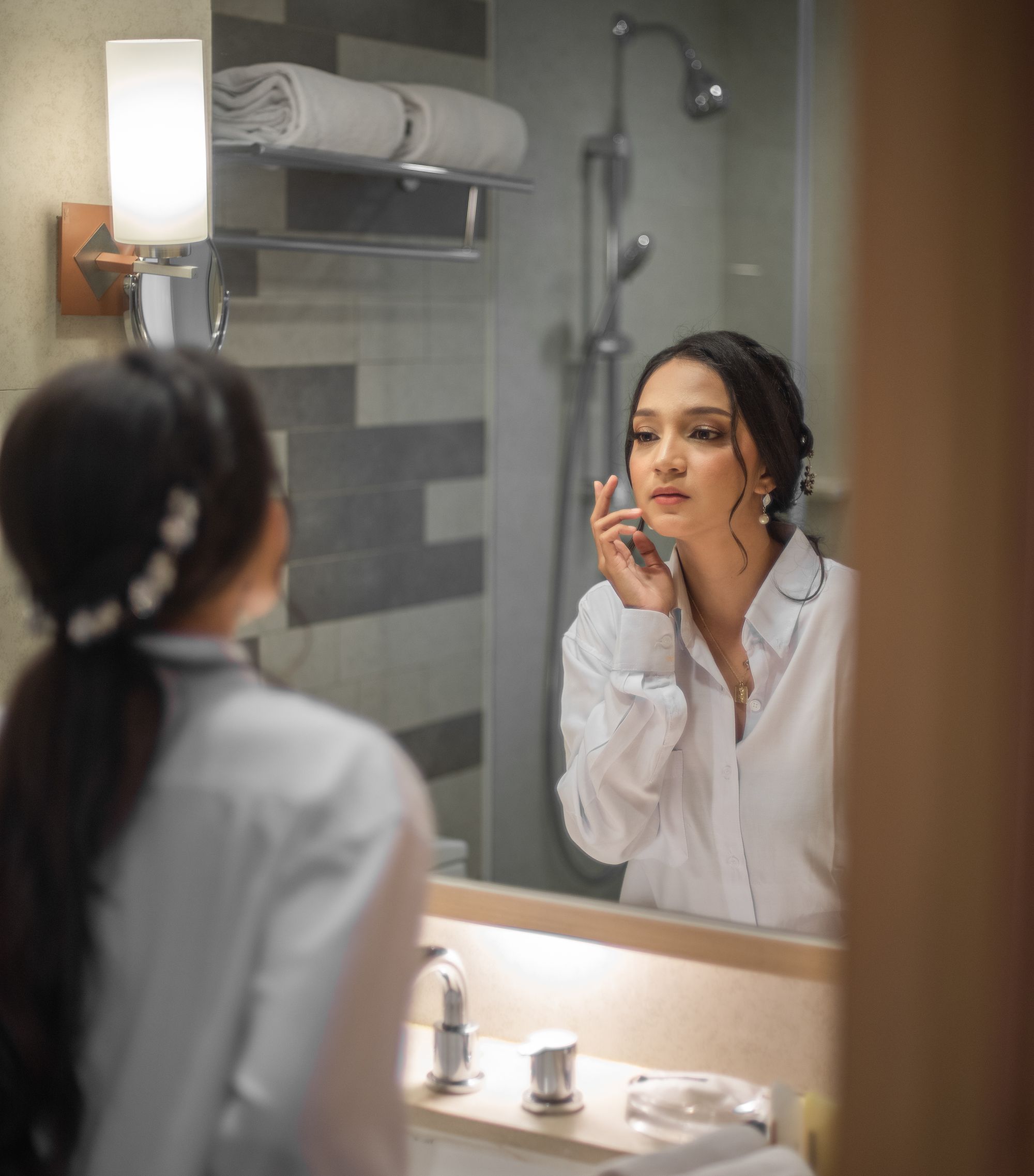 Young Woman Standing in front of a Mirror in a Bathroom · Free Stock Photo