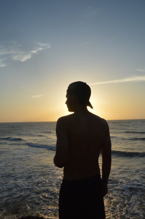 Man Silhouette on Sea Shore at Sunset
