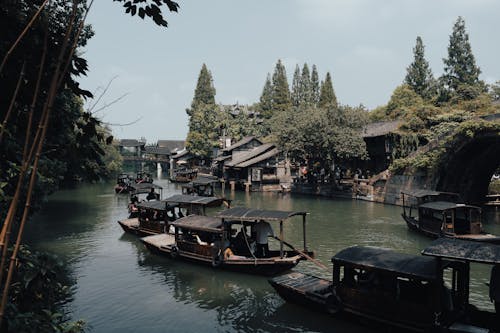 Wooden Boats on River in Village