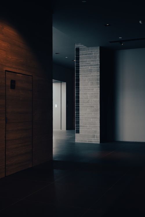 Free Dark, moody interior of a modern architectural space with textured walls and minimal lighting. Stock Photo