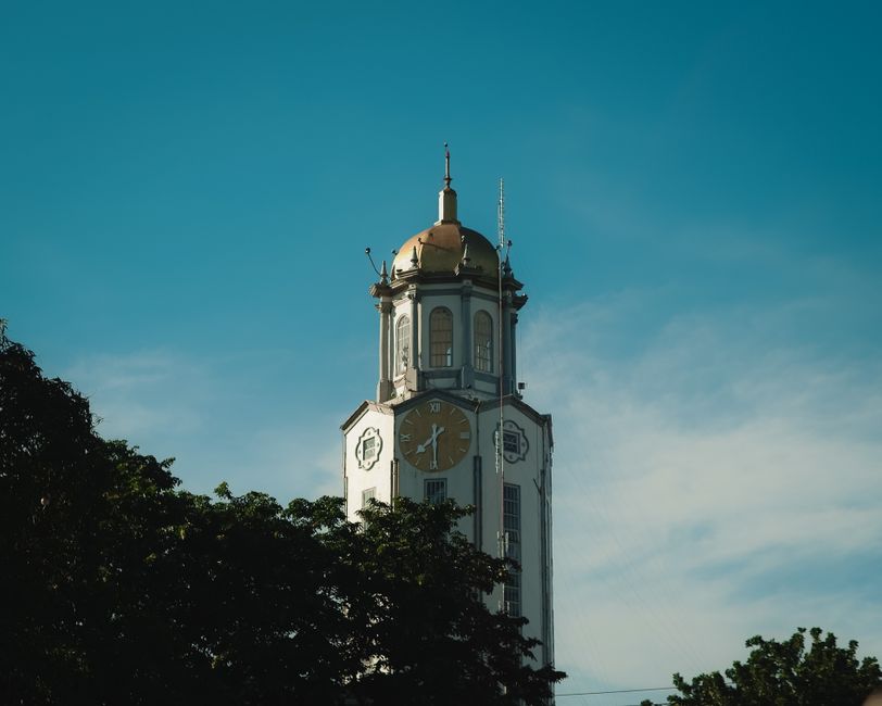 Iconic clock tower in Manila, Philippines under a vibrant blue sky.
