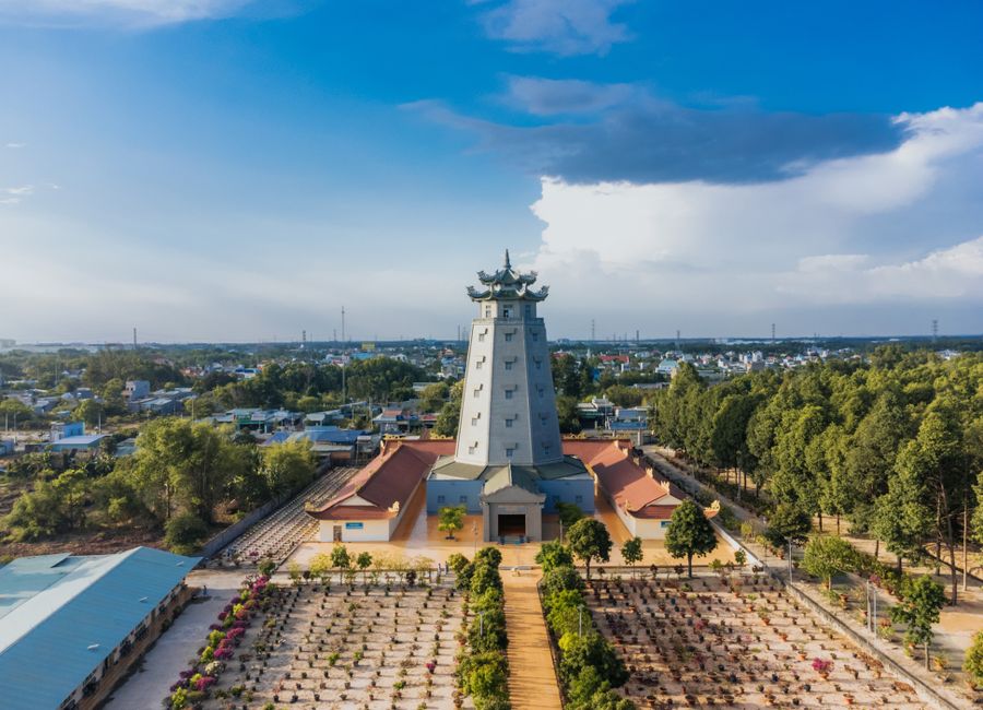 Aerial shot of Dai Tong Lam Pagoda in Phú Mỹ, Vietnam with surrounding landscape and vibrant sky.
