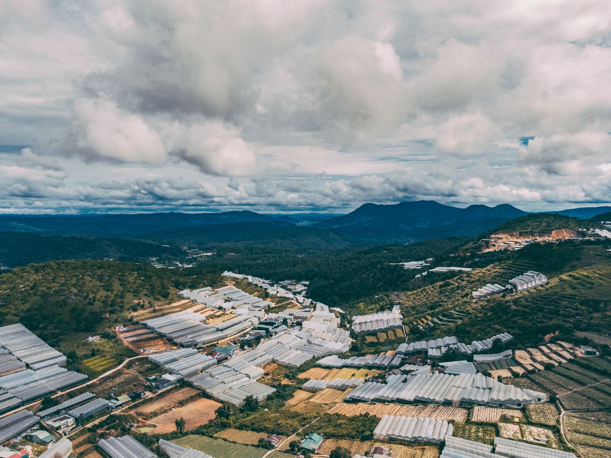 Da Lat hills with greenhouses, fields and buildings