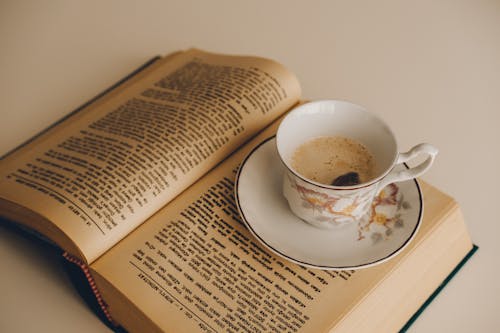Free Cup of Coffee on Opened Book Stock Photo