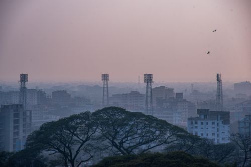 Free Aerial view of a cityscape with tall buildings and trees at dusk, showcasing urban life. Stock Photo