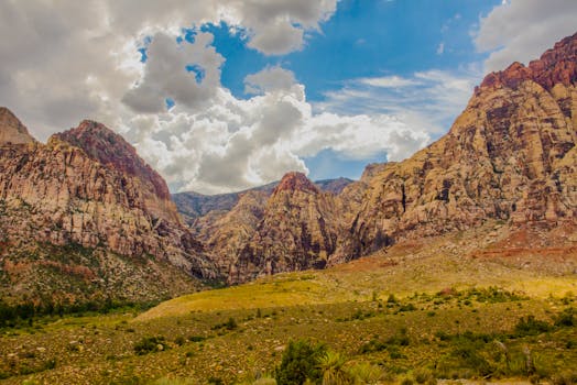 Captivating view of a rocky canyon with dramatic clouds and rich textures under a blue sky.