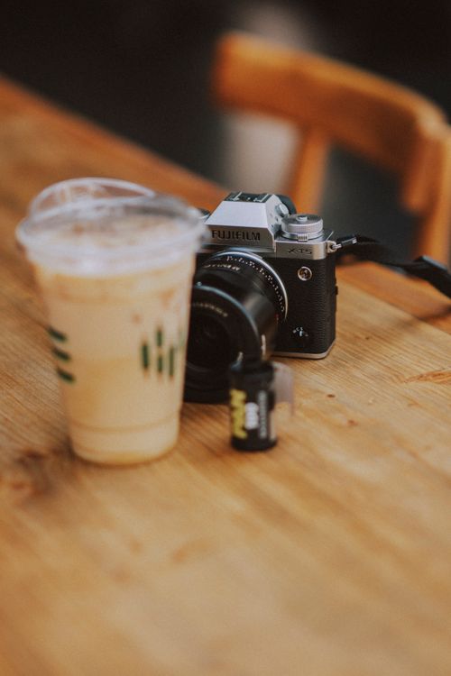 Free Close-up of a camera and iced coffee on a restaurant table. Stock Photo
