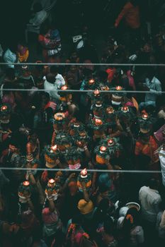 A captivating aerial view of a Hindu ritual with people holding candles, embracing cultural traditions in an urban setting.