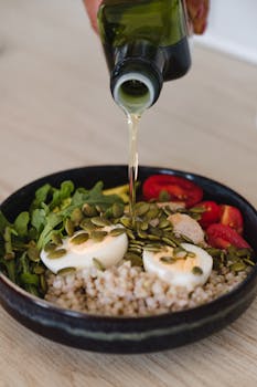 Delicious whole grain salad with fresh vegetables, pumpkin seeds, and olive oil pour.
