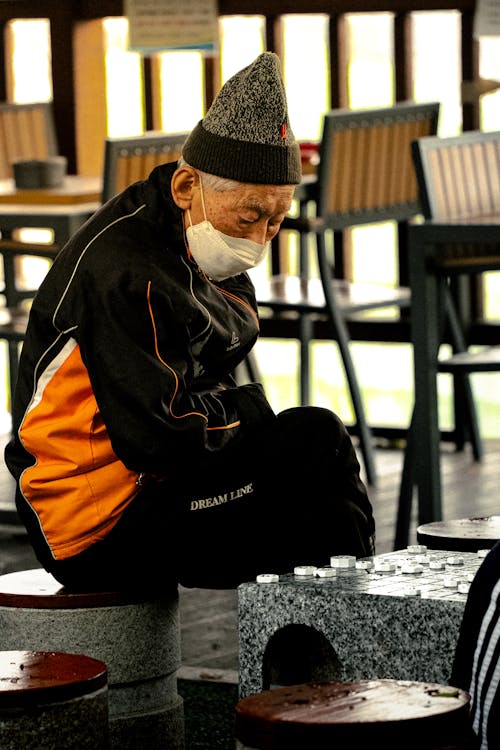 Kostenloses Stock Foto zu asiatischer mann, brettspiel, gesichtsmaske