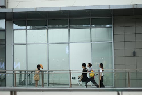 People Walking in front of a Modern Building in City 