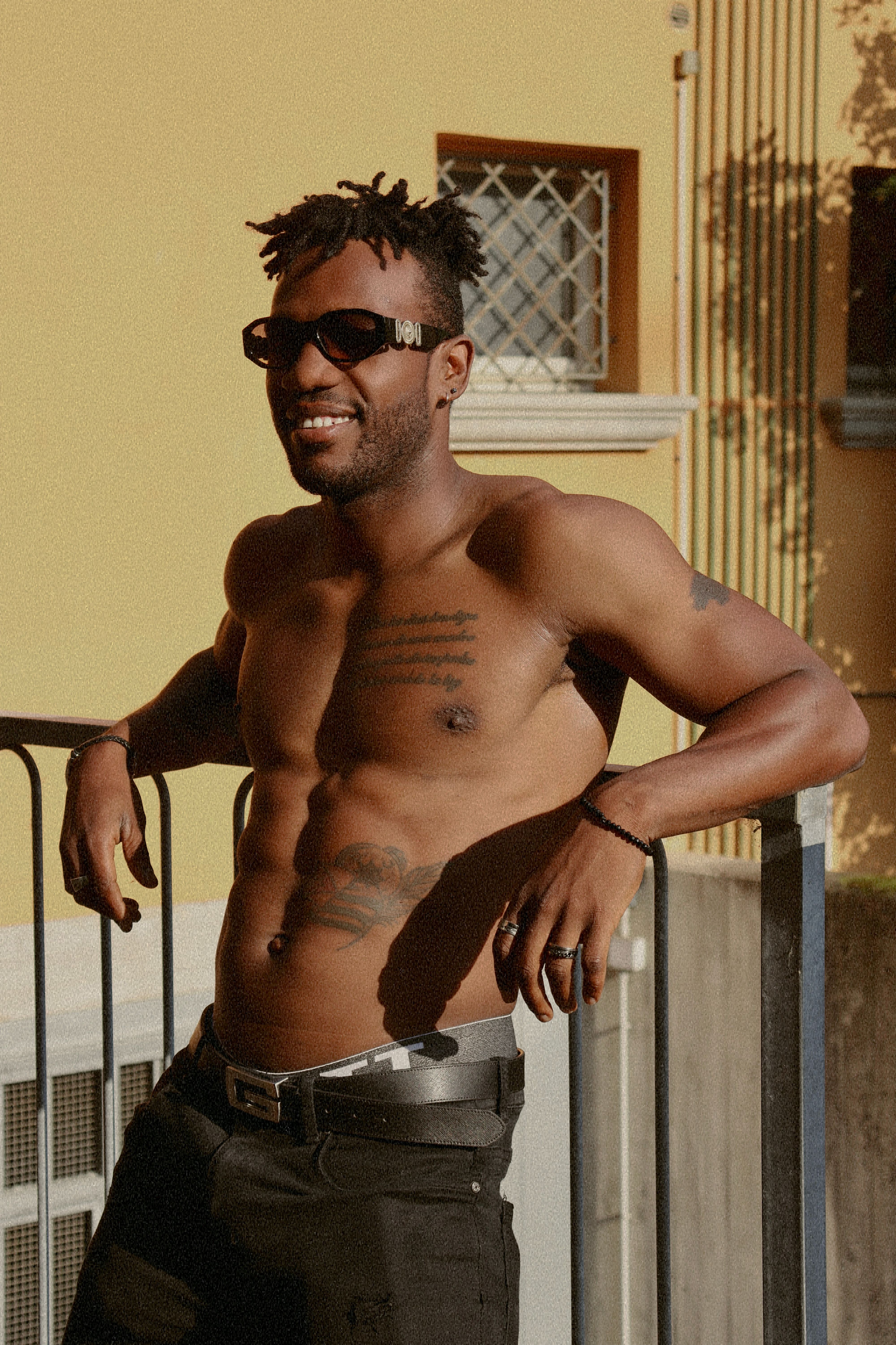 Portrait of a smiling shirtless man with sunglasses, enjoying outdoors in San Giovanni, Italy.