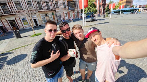 group of young friends make selfie photo with smartphone camera in city while traveling. Outdoor activity of young students away from home.