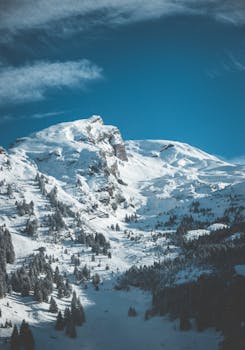 冰雪覆盖的山峰映衬着深蓝色的天空，捕捉到了冬季的美丽