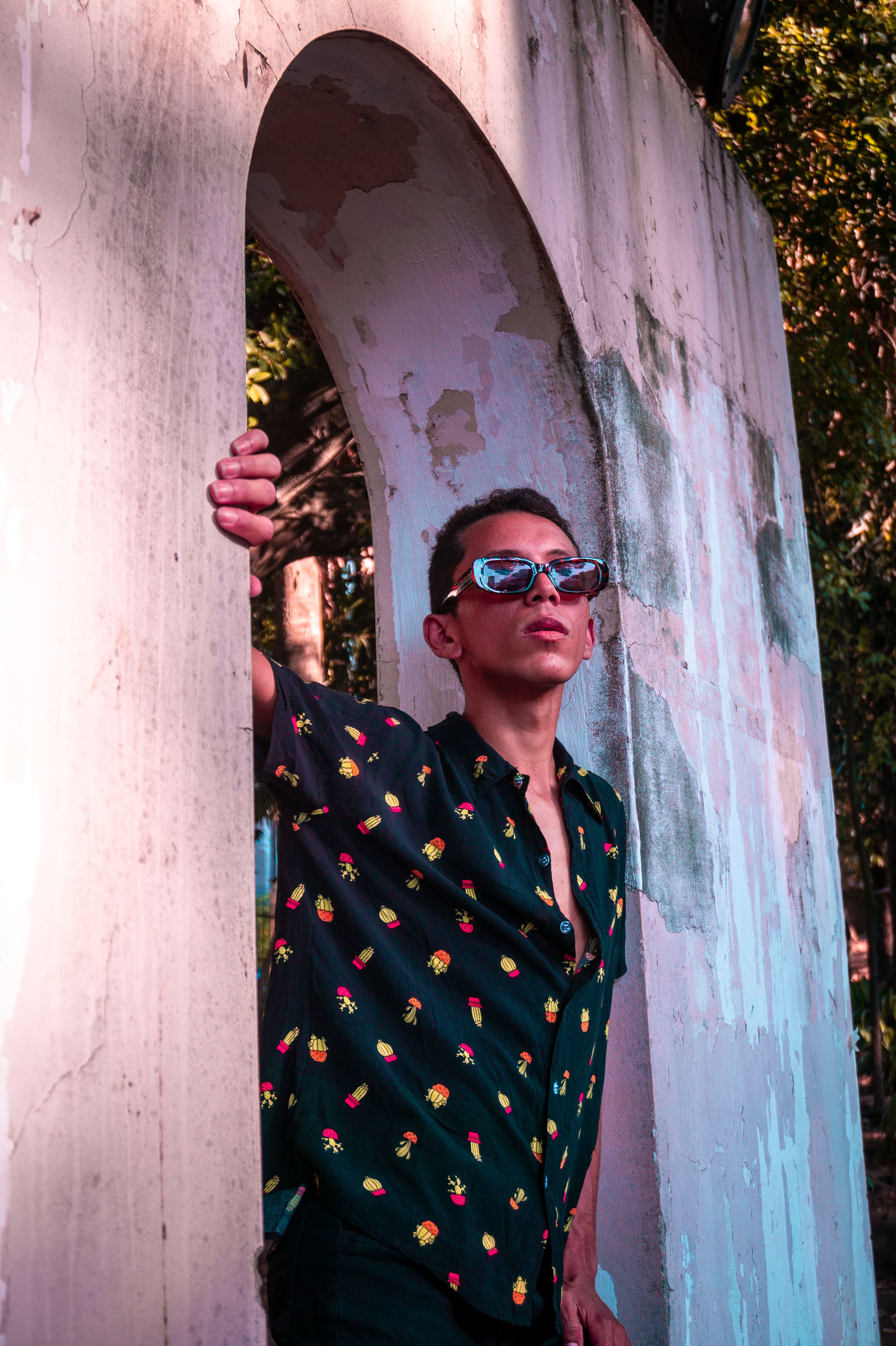 A man in sunglasses leaning against a wall · Free Stock Photo
