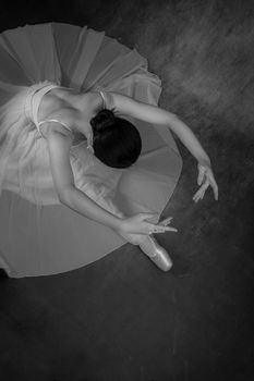 Black and white photo of a ballerina in an elegant pose captured from above.