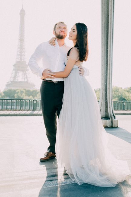 Newlyweds embrace near the Eiffel Tower, capturing a romantic Parisian wedding moment.