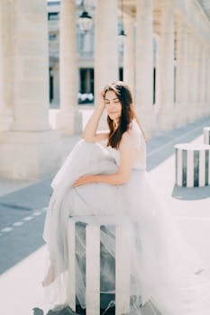 Bride sitting in a wedding dress among colonnades, embracing elegance and style.