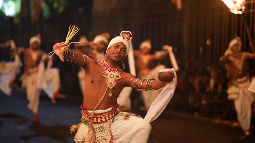 Free Dynamic night-time tribal dance showcasing traditional costumes and vibrant energy. Stock Photo