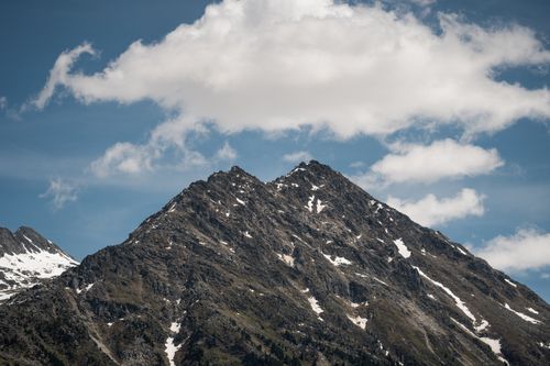Free A majestic mountain peak with patches of snow under a cloudy sky, showcasing natural beauty. Stock Photo