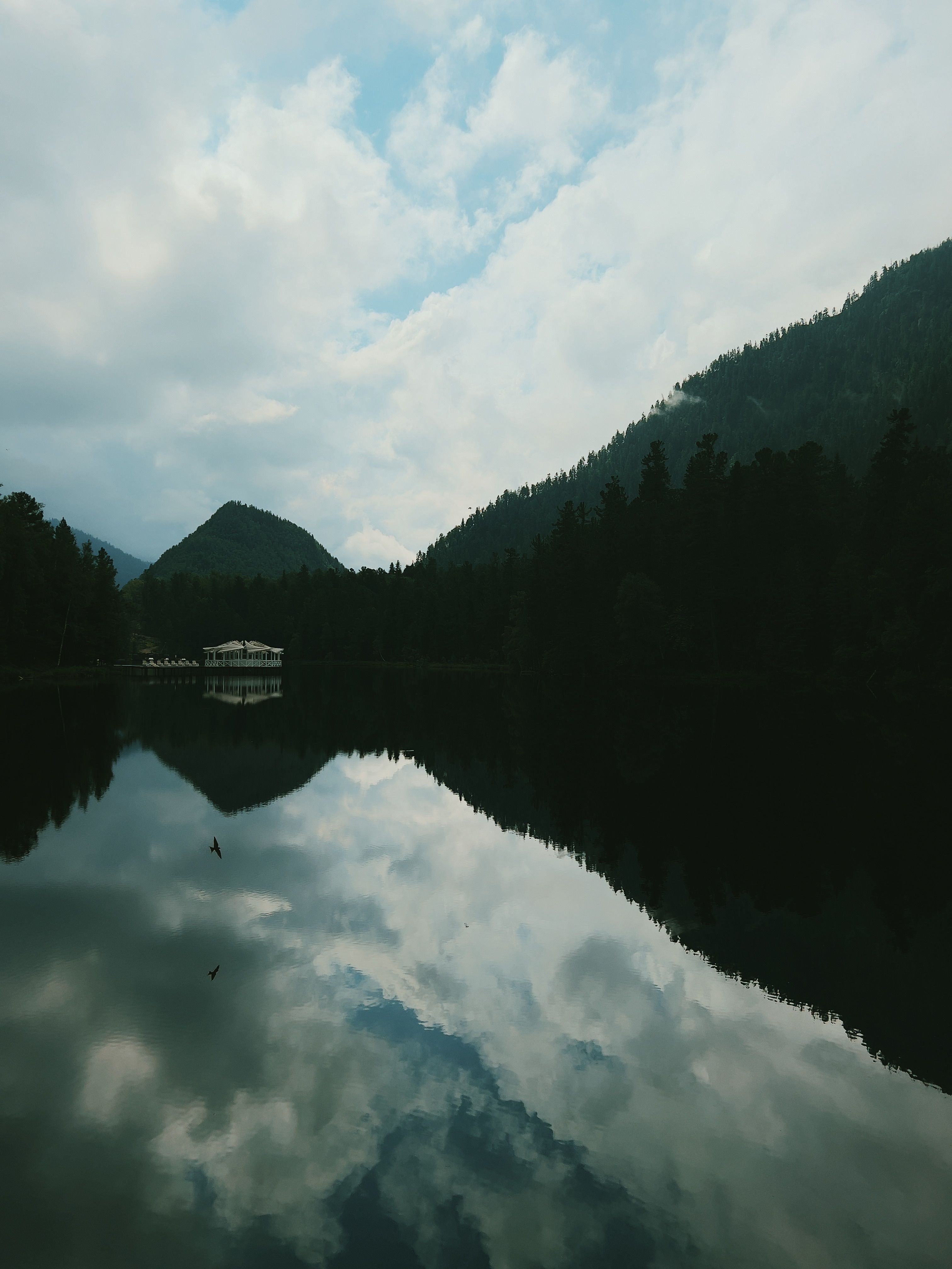 Calm lake reflecting mountains at dawn